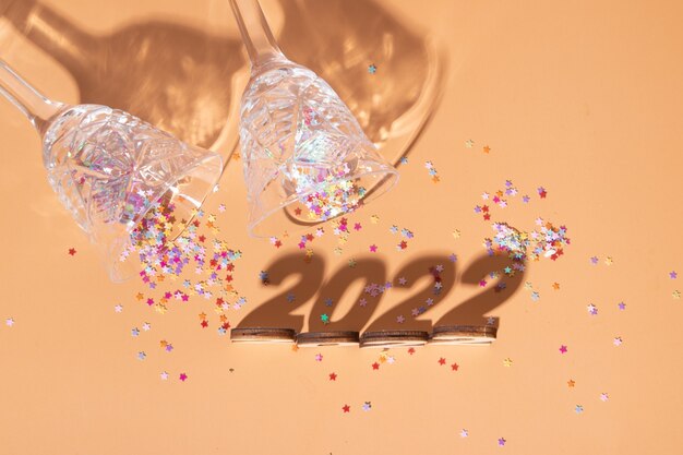 Feestelijke nieuwjaarsplattegrond met nummers 2022 en harde schaduwen met bril en glanzend decor