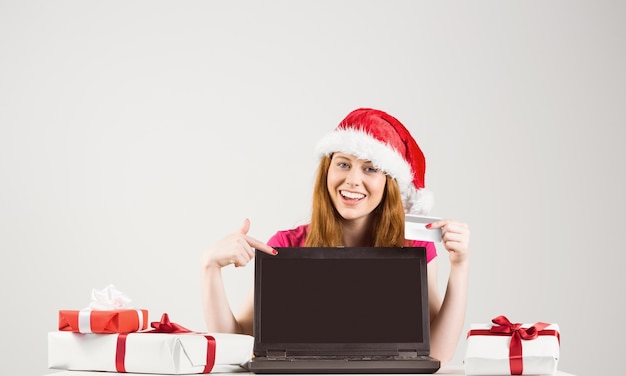 Feestelijke roodharige online winkelen met laptop