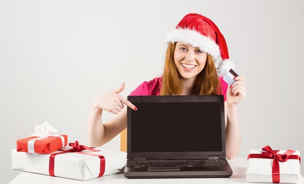 Feestelijke roodharige online winkelen met laptop