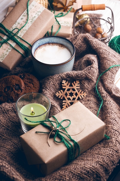 Feestelijke stemming. Geschenken, kopje cappuccino en kerst decor op de houten achtergrond.