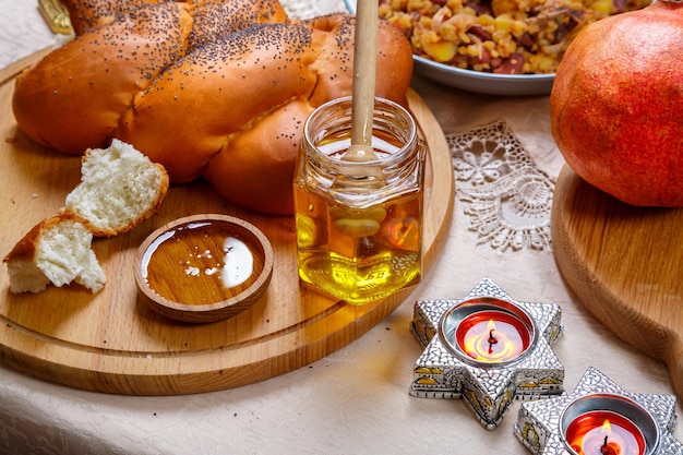 Feestelijke tafel Rosj Hasjana challah honing appels traditioneel eten en brandende kaarsen