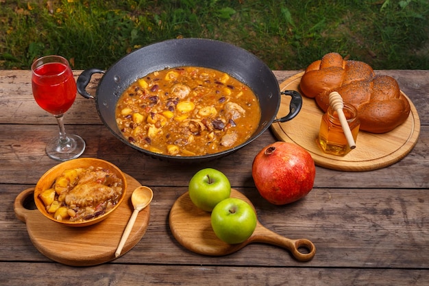 Feestelijke tafel voor Rosj Hasjana cholent met kip granaatappel wijn honing appels challah