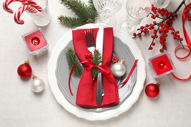 Feestelijke tafelschikking met mooi servies en kerstdecor op witte achtergrond plat gelegd
