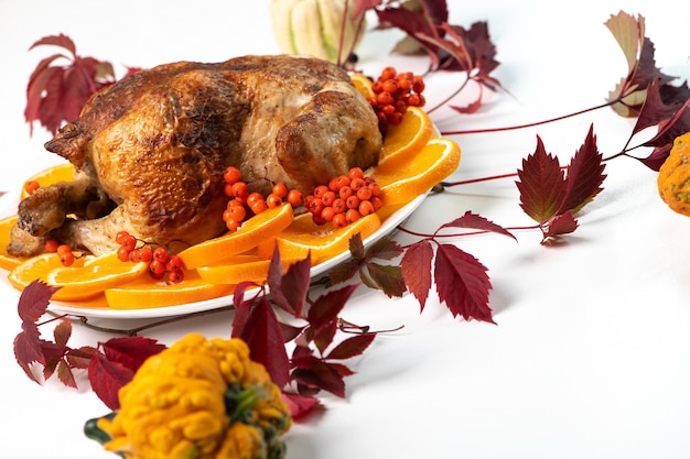 Feestelijke viering geroosterde kip met stukjes sinaasappel en lijsterbessen voor Thanksgiving of kerstdiner Selectieve focus met kopieerruimte