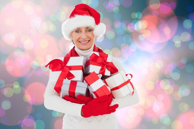 Feestelijke vrouw met geschenken tegen licht gloeiende stippen op blauw