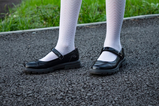 Feet in black shoes stand on the sidewalk