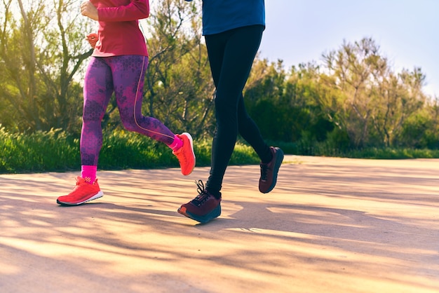 Feet detailed shot of two person running outside Colorful bright sportswear