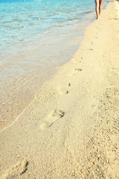 A Feet and footprints by the seashore in nature travel vacation background