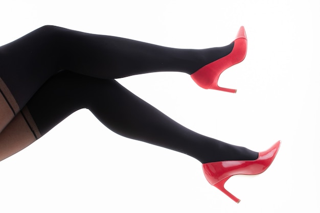 Feet of a girl in pantyhose with red shoes