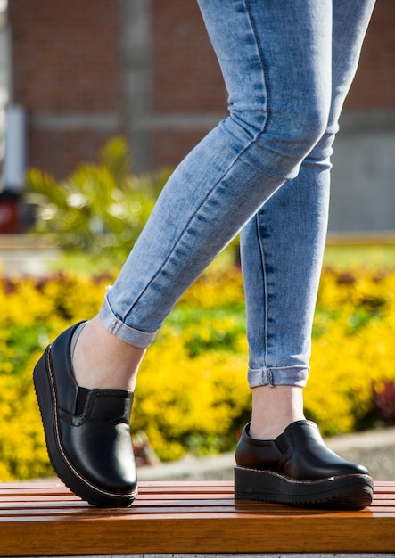 Photo feet and legs with different types of casual and elegant shoes on various natural and urban backgrounds without brand