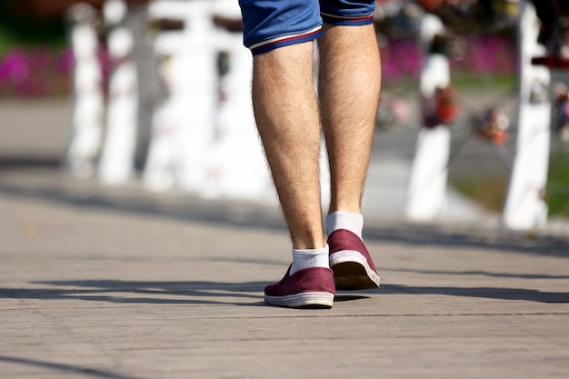 The feet of the man walking on the wooden bridge