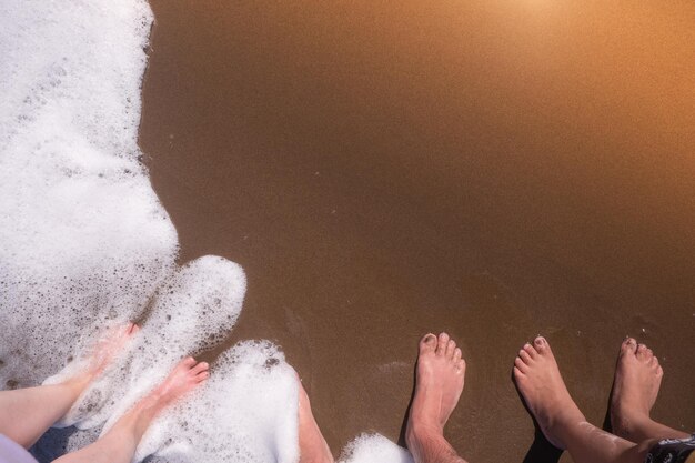 Photo feet of people enjoying on the beach