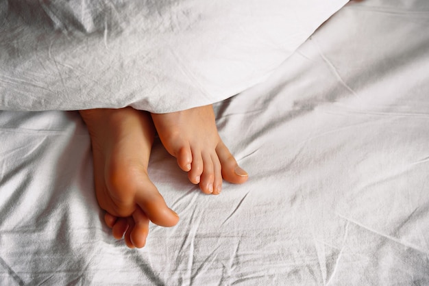 Photo feet protruding from the duvet