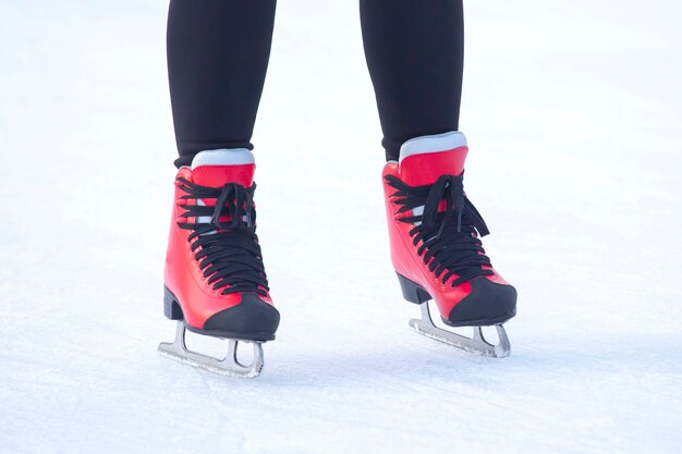 Feet in red skates on an ice rink. hobbies and leisure. winter sports