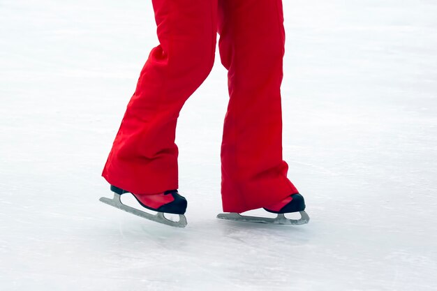 アイススケートリンクの赤いスケート靴の足。趣味とスポーツ。休暇や冬のアクティビティ。