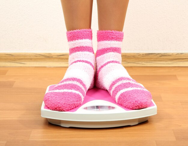 Feet on scales on floor in room