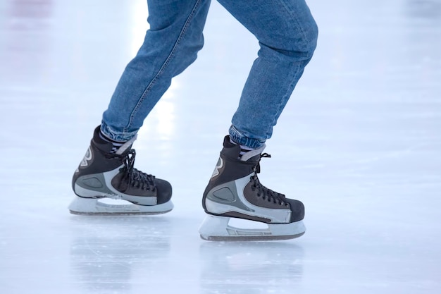 Feet on the skates of a person rolling on the ice rink