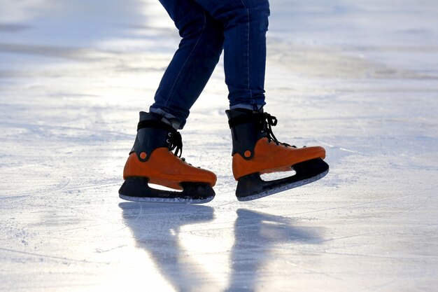 Feet on the skates of a person rolling on the ice rink