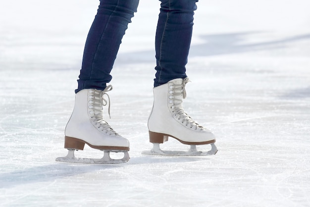 Piedi pattinaggio ragazza pattinaggio sulla pista di pattinaggio su ghiaccio