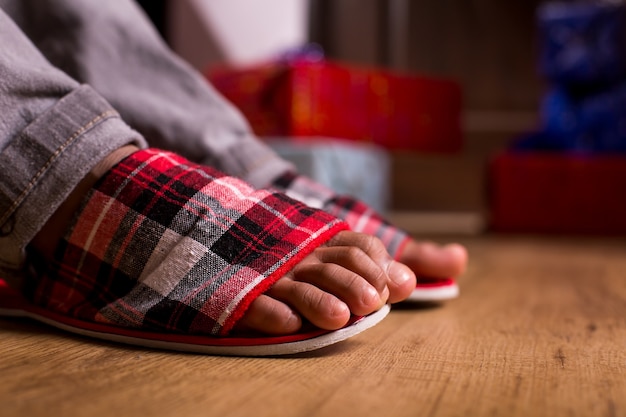 Feet in slippers beside presents gift boxes beside childs feet morning surprise is waiting what are ...