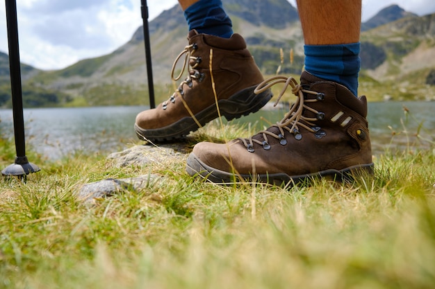 Photo feet in trekking boots on the ground