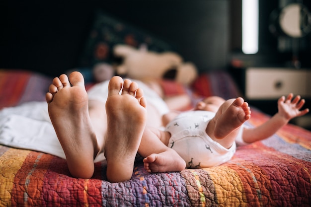 Photo feet of two siblings on the bed