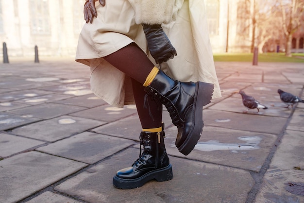 Feet of a woman in a black shoes on the city street on cold day