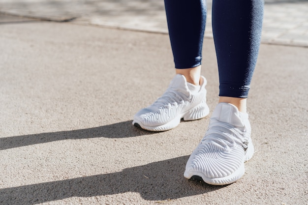 Feet of a woman dressed in sportswear and sneakers for\
running