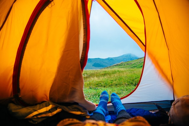 Feet woman relaxing enjoying vacation veiw from tent camping Travel lifestyle concept beautiful mountains landscape High quality photo