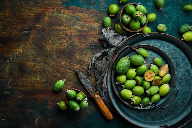 Frutti di feijoa o frutti verdi esotici di guava di ananas vista dall'alto su uno sfondo di pietra nera