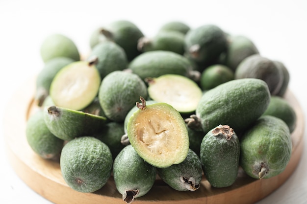 Feijoa groen op een lichte achtergrond. Feijoa Selloana is een fruitgewas uit tropische streken. Biologisch gezond voedselconcept, milieuvriendelijke natuurlijke producten, vegetarische, rauwe producten.