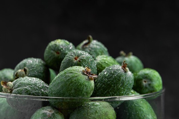 Foto feijoa intero su sfondo nero. frutta esotica. messa a fuoco selettiva. avvicinamento.