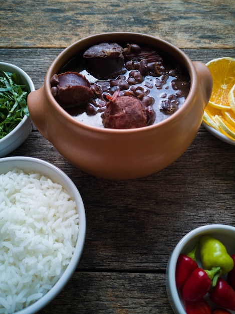 세라믹 그릇에 있는 Feijoada, 나무 배경에 있는 전통 브라질 음식.