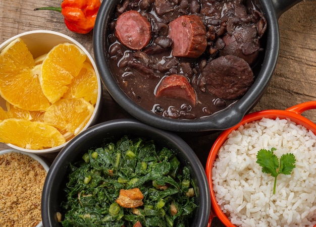 FEIJOADA typical and traditional food of Brazilian cuisine served with rice farofa orange pepper and cabbage