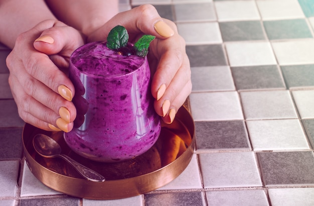 Fel paarse smoothie geserveerd aan de tafel.