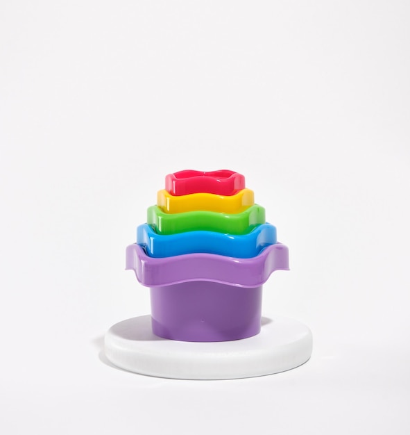 Foto fel veelkleurig speelgoed voor zand op een witte ronde standaard samenstelling van kinderspeelgoed