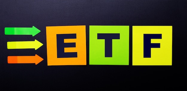 Felgekleurde papieren stickers op een zwarte achtergrond met de tekst etf exchange traded funds