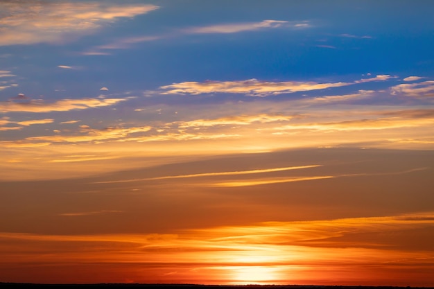 Felle warme zon op de hemelachtergrond. Dageraad of zonsondergang.