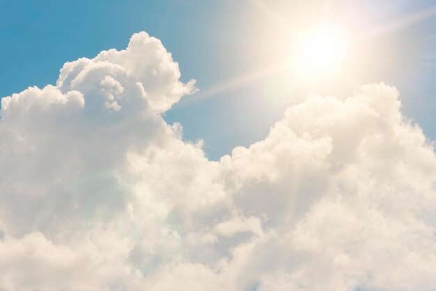 Felle zon op blauwe lucht met witte pluizige wolken achtergrond