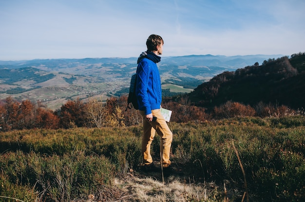 fellow tourist with map in hand and phone. autumn mountains