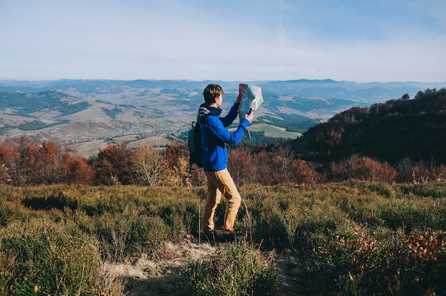 fellow tourist with map in hand and phone. autumn mountains