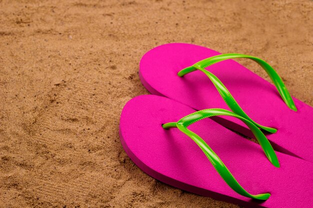 Felroze pantoffels op het strand