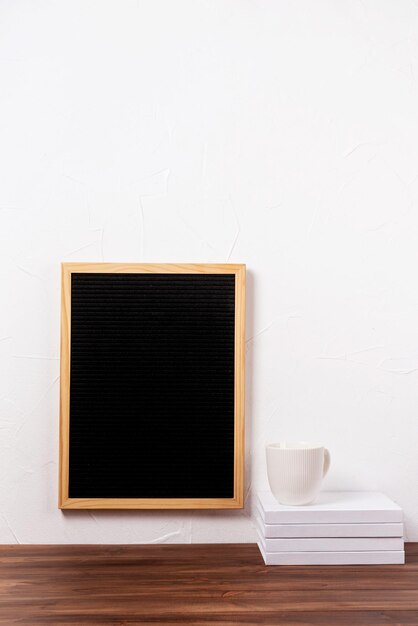 Felt letter board hanging on the wall with stack of books and coffee cup