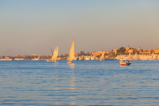 Лодки Felucca, плывущие по реке Нил в Луксоре, Египте Традиционные египетские парусные лодки