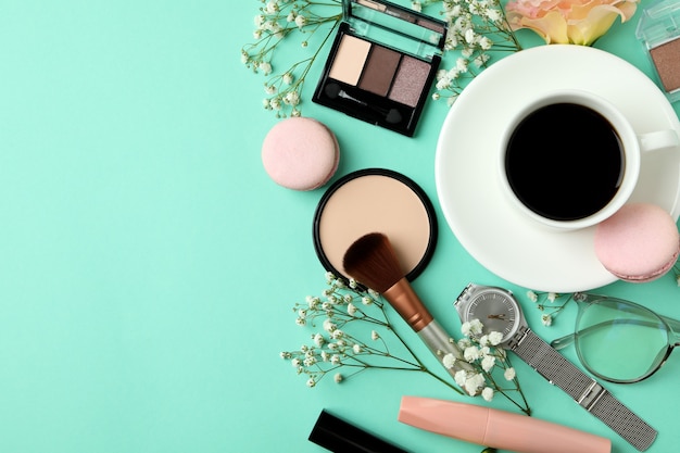 Female accessories and macaroons on mint background