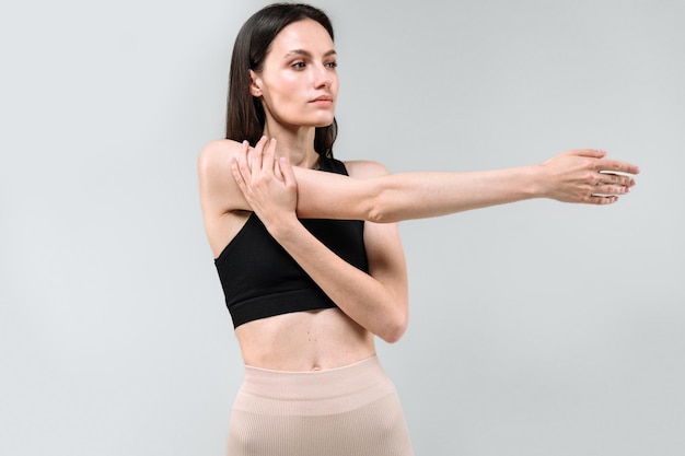 Female in activewear warm up her upper body before yoga training