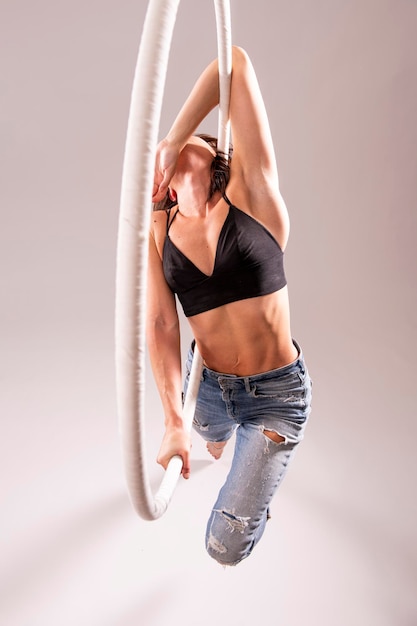 A female Aerial hoop gymnast performing exercises on an Aerial hoop