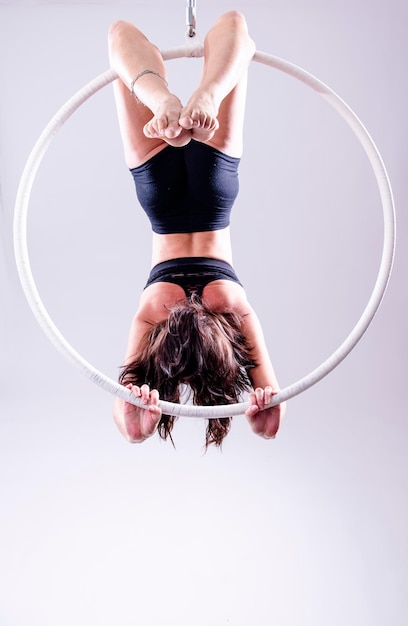 Photo a female aerial hoop gymnast performing exercises on an aerial hoop