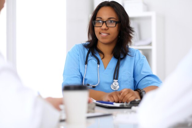 Female african american medical doctor with colleague in hospital.