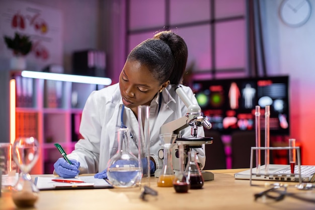 Женщина-афро-американский ученый, работающая в лаборатории